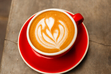 Cappuccino coffee in red cup on concrete table Delicious flat white with latte art on a gray background