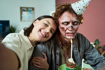 Young Woman Taking Selfie With Her Zombie Husband On His Birthday