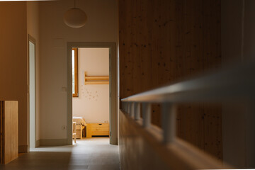 Warm and inviting hallway leading to a cozy bedroom in a modern home decorated with wooden accents