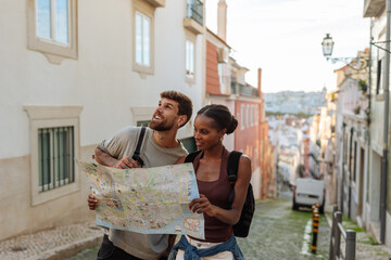 Tourists consulting map exploring lisbon streets during vacation
