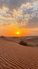 As the sun dips below the horizon, the desert transforms into a canvas of gold and orange. Silhouetted dunes showcase intricate patterns under a colorful sky, inviting tranquility and reflection