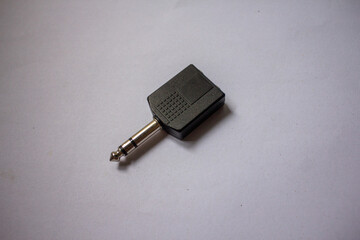 A stereo Akai jack adapter to two Akai mono jacks is photographed on a plain white...