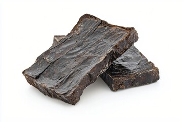 Two pieces of dark brown beef jerky stacked on a white surface in a studio shot style