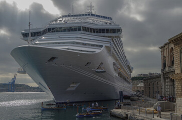 Gigantic cruiseship cruise ship liner Fascinosa docked at pier terminal in old town Valletta, Malta...