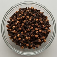 Black cloves in glass bowl isolated top view