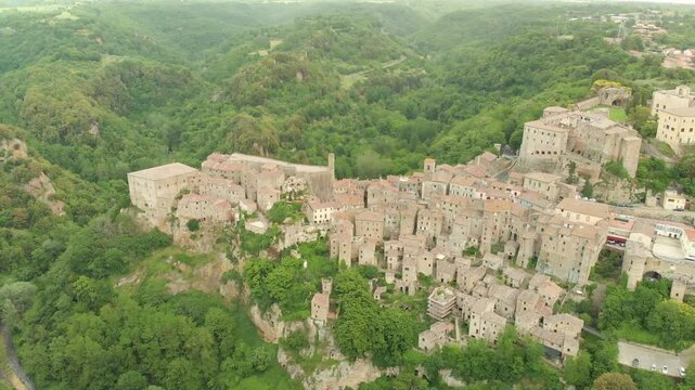 Aerial summer afternoon view of Sorano. Rooftops of an ancient medieval hill town hanging from a tuff stone over the Lente River. Etruscan heritage. Province Grosseto, Tuscany, Italy.