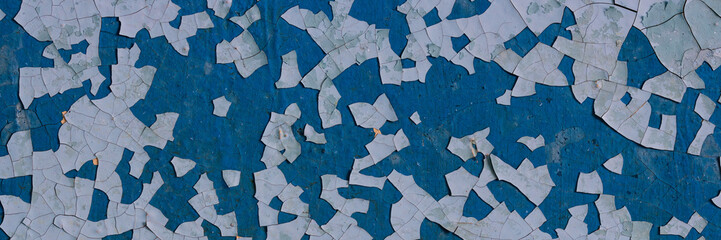 Peeling paint on the wall. Panorama of a concrete wall with old cracked flaking paint. Weathered...