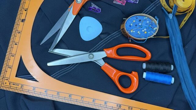 Time lapse video of blue silk fabric. Woman's hand lays out necessary supplies for sewing dress on fabric on table. DIY concept. Sewing as a hobby. Flat lay, close-up, top view, fast motion