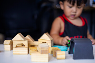 A Toddler Is Playing With A Toy Blocks At Home