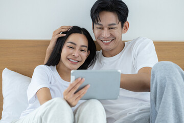 Happy couple watching movies and dramas on the bed