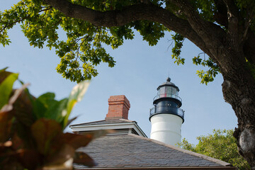 White Lighthouse on a sunny day. Key West,  Florida. Framed with trees on sides against a blue sky...