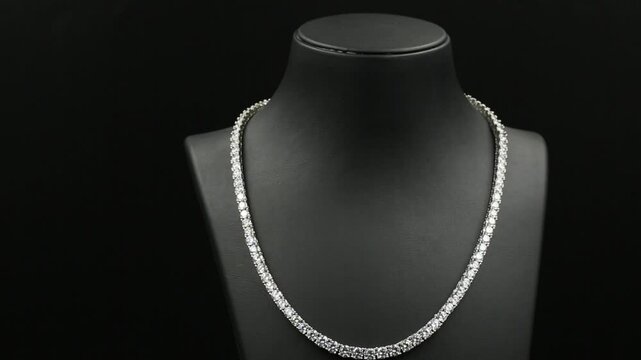 A stunning double-layered diamond necklace displayed on a sleek black jewelry bust, exuding elegance and sophistication. This high-quality 4K close-up video captures the intricate details.