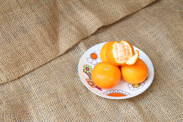 Top view of pile citrus fruits on a plate. Peel the orange to reveal some of the inner flesh.. Wogan Orange. Fruits contain vitamins.