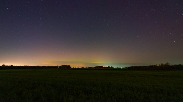 Aurora Borealis over suburbs fields and clouds - timelapse