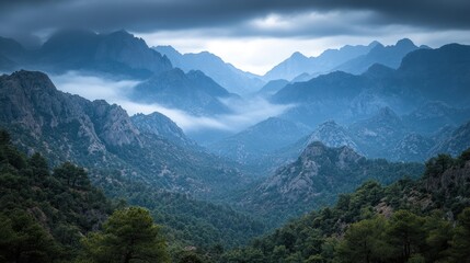 Fototapeta premium Misty mountain range under a dramatic sky.