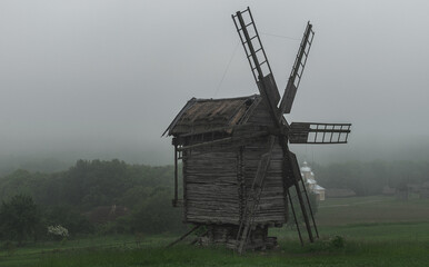 Old wooden mills on the outskirts of a medieval farm on a gloomy and rainy day.