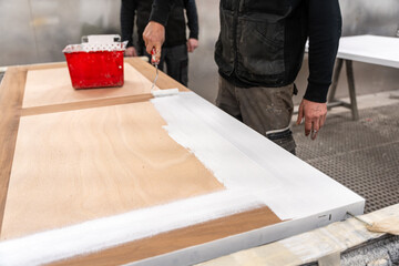 Gros plan de gestes précis et de matériaux en bois dans un atelier de menuiserie, capturant l'artisanat du bois à l'œuvre.