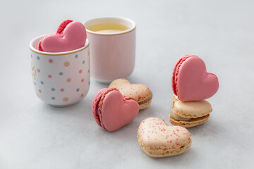 Macaron cake or heart shaped french macaroons in a postal envelope on a light background. Delicious dessert for a celebration - birthday, Valentine's Day, wedding day, christening. Love