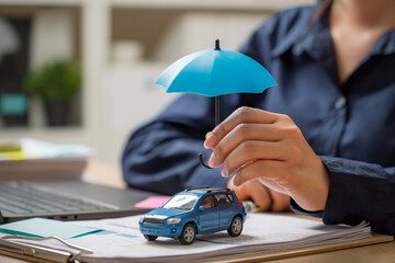 Woman hand holding umbrella over car, symbol for car protection,symbolizing car insurance. © Pugun & Photo Studio