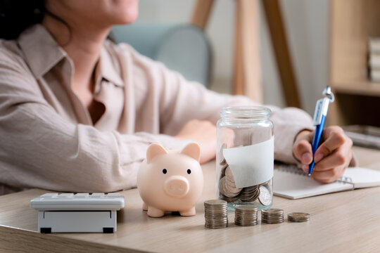 Asian woman hand put coins in piggy bank,Saving money wealth and financial concept. 