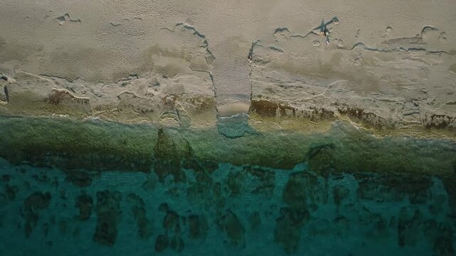  Aerial View of a Stone Passage Leading to Turquoise Sea on a Sandy Beach