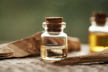 A bottle of aromatherapy essential oil with pieces of white sandalwood
