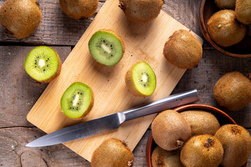 Sweet kiwi fruits, whole and sliced, on kitchen table copy space. Green and golden kiwi assortment 