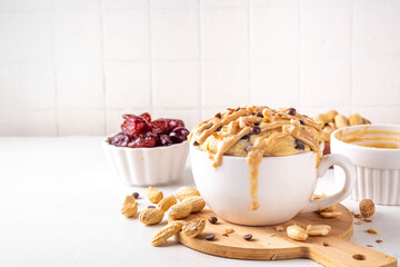 Healthy vegan Peanut Butter banana bread Mugcake, Rich and delicious peanut buttery microwave made mug cake with dates, chocolate drops, with Peanut Butter topping, nuts and chocolate