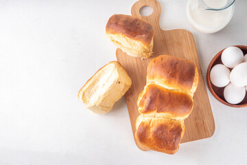Japanese bread Shokupan, Hokkaido milk bread, or simply milk fluffy buns, on kitchen table, copy space