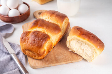Japanese bread Shokupan, Hokkaido milk bread, or simply milk fluffy buns, on kitchen table, copy space
