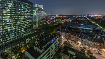 Obraz premium Aerial night timelapse of Brussels urban landscape blending office skyscrapers with residential areas.