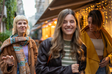 Fototapeta premium Three young women enjoying a night out together in the city lights