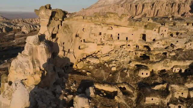 Drone view of the &Ccedil;avuşin Kalesi castle caves in the sunset rays in Cappadocia