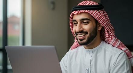 Smart and safe electronic marketing through social media, browsing the Internet and working remotely via a laptop, a close-up portrait of a smiling Saudi Gulf Arab young man wearing a traditional thob