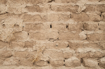 Ancient adobe wall plastered with mud closeup