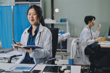 Obraz premium Positive doctor working on laptop in medical office, portrait.