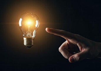 index finger pointing at an illuminated bulb