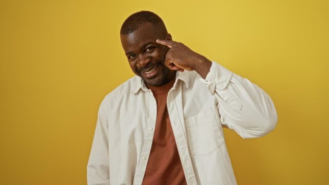 African american man wearing shirt standing with head pointing finger for great idea and good memory over isolated yellow background