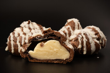 Profiteroles with coconut cream on a black background.