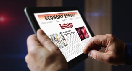Embargo trade sanctions newspaper on mobile tablet screen