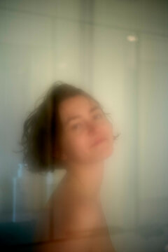 Blurred portrait of a woman with short hair behind frosted glass in the shower, creating a dreamy effect, Miami, Florida, USA