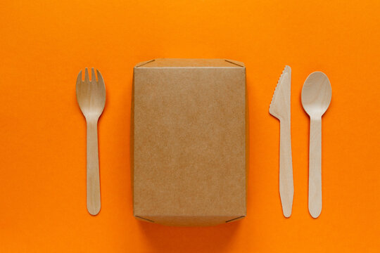 wooden disposable cutlery - knife, fork, tablespoon and container on orange bachground
lunch
environmental problem 