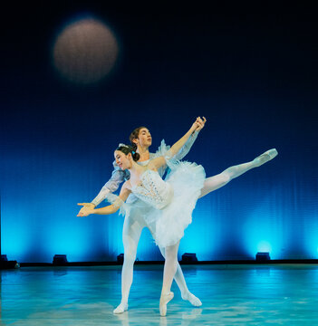 Two ballet dancers perform gracefully on stage under a blue spotlight. The Nutcracker, Bainbridge Island, USA