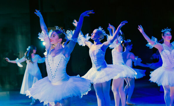 Ballet dancers in white tutus perform gracefully on a dimly lit stage. The Nutcracker, Bainbridge Island, USA