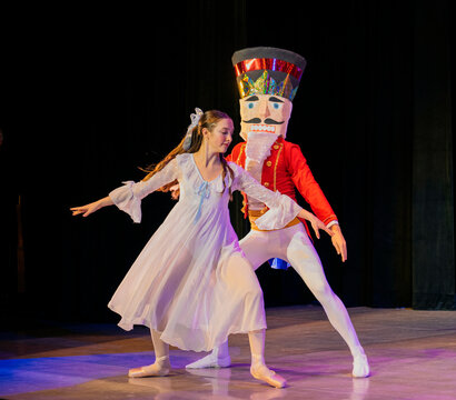 Ballet dancers performing a scene with a Nutcracker character on stage in elegant costumes. The Nutcracker, Bainbridge Island, USA