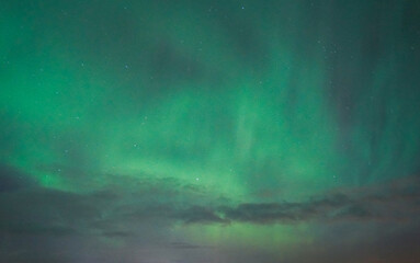 Magical green aurora lights dancing in sky.