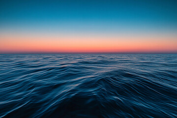 Obraz premium Sunset over calm ocean waters creates a serene atmosphere with vibrant colors on the horizon