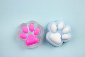 Cute colorful cat paw shape squishy jelly slime toys on blue background, studio shot, copy space. Modern popular sensory toy concept. © FotoHelin
