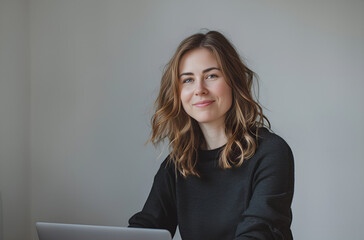 Naturalny portret uśmiechniętej kobiety w minimalistycznym wnętrzu.