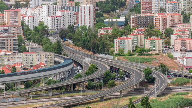 Aerial top view of highway multilevel junction road in urban populated area timelapse.